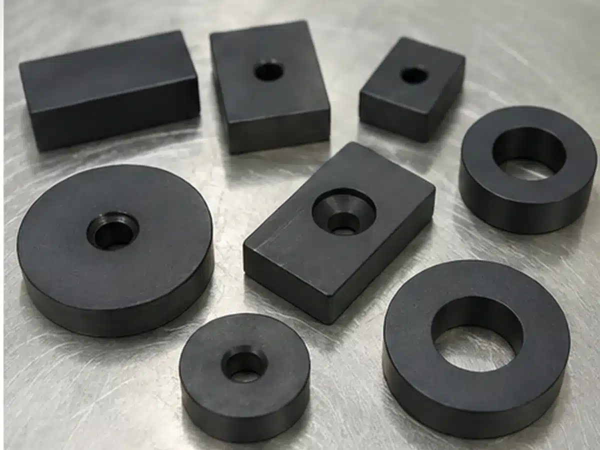 Illustration of custom PTFE coated magnet shapes with holes and countersunk features